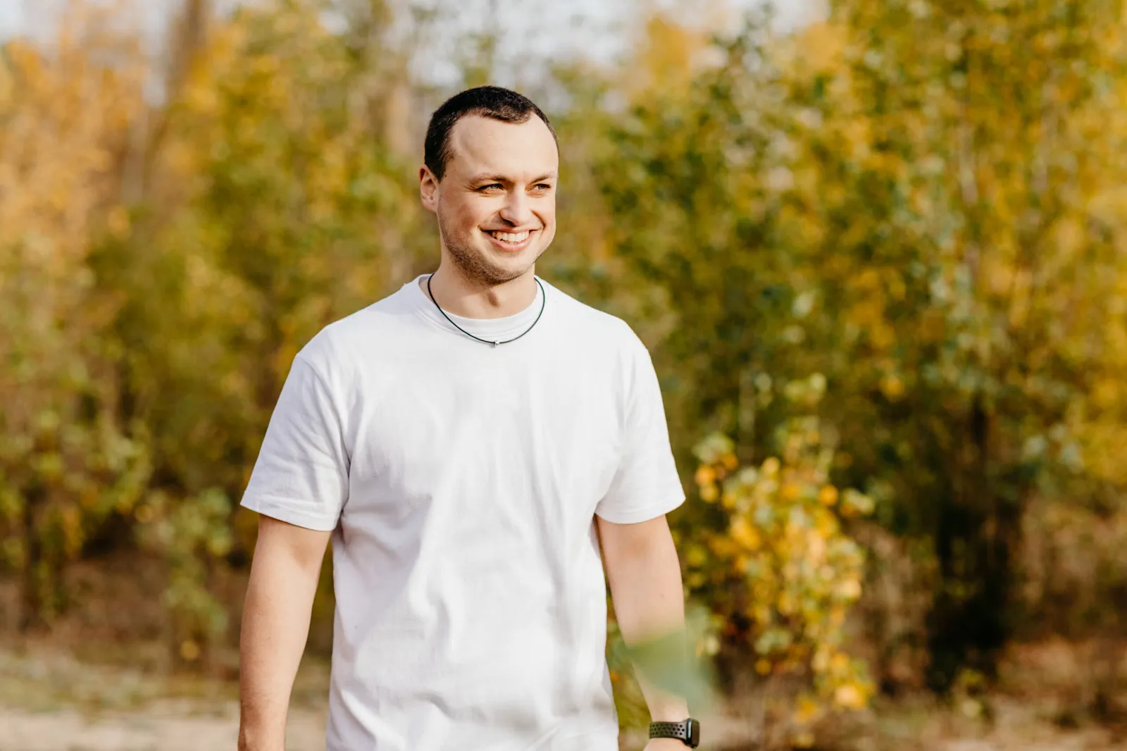 Timo Maletschek im weißen T-Shirt in herbstlicher Natur