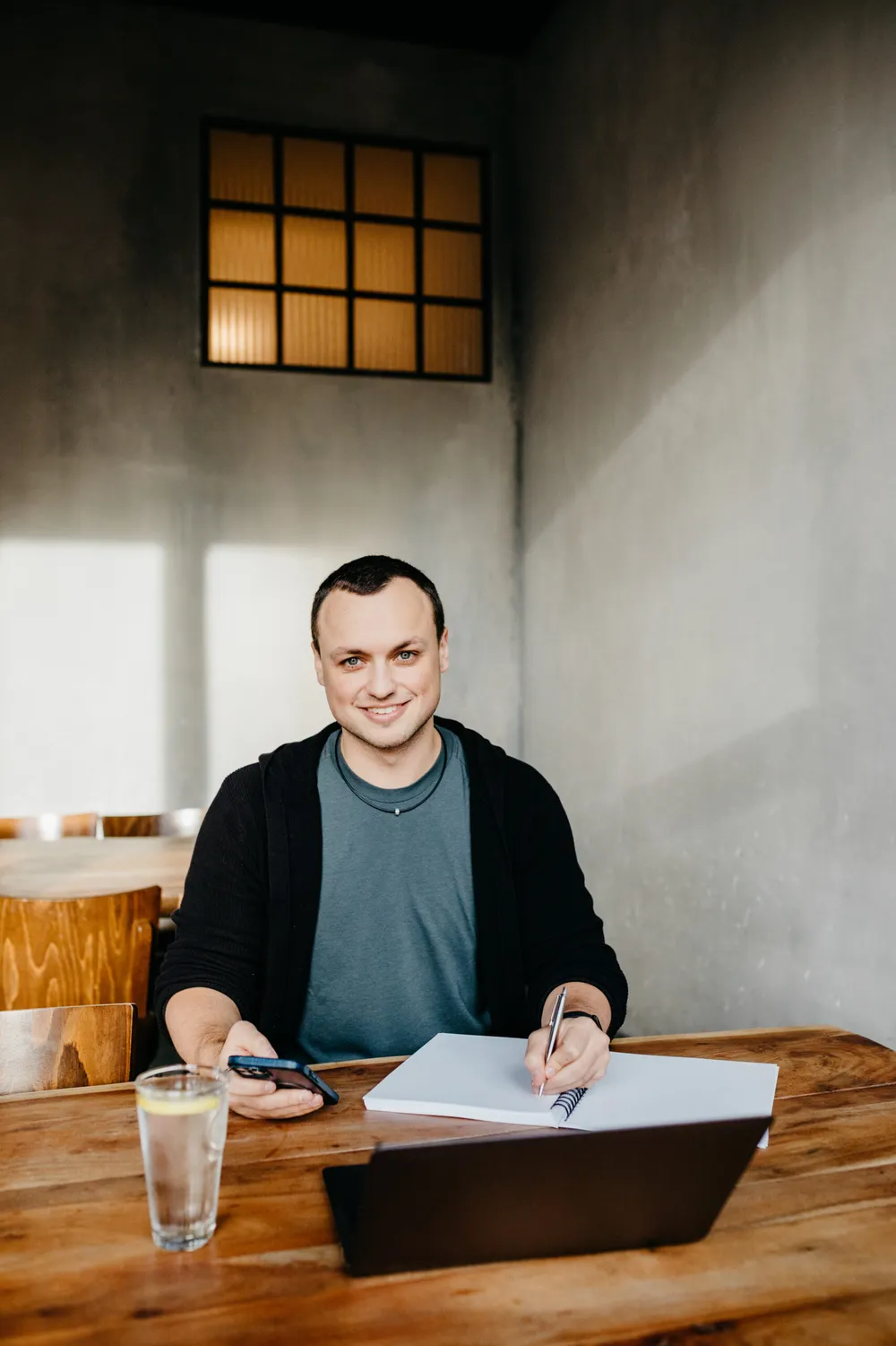 Timo Maletschek am Schreibtisch mit Laptop und Notizbuch